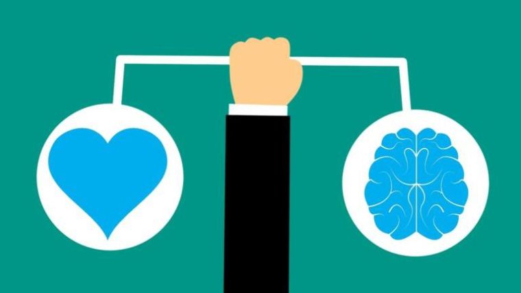 Image shows fist holding weighing scales, with a heart balanced on the left and the brain on the right.