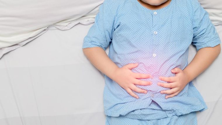 Child holding stomach and red spot indicating location of pain