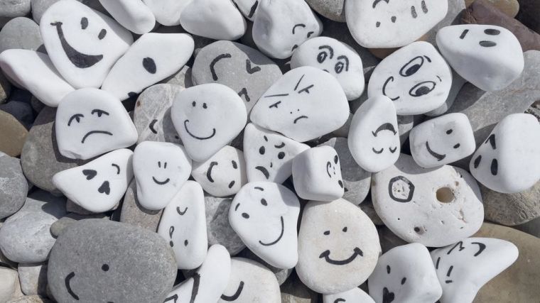 Emotion management concept, stones with painted faces symbolize different emotions.