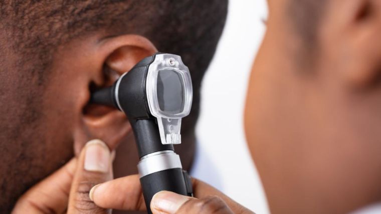 A man having his ear looked at by a doctor